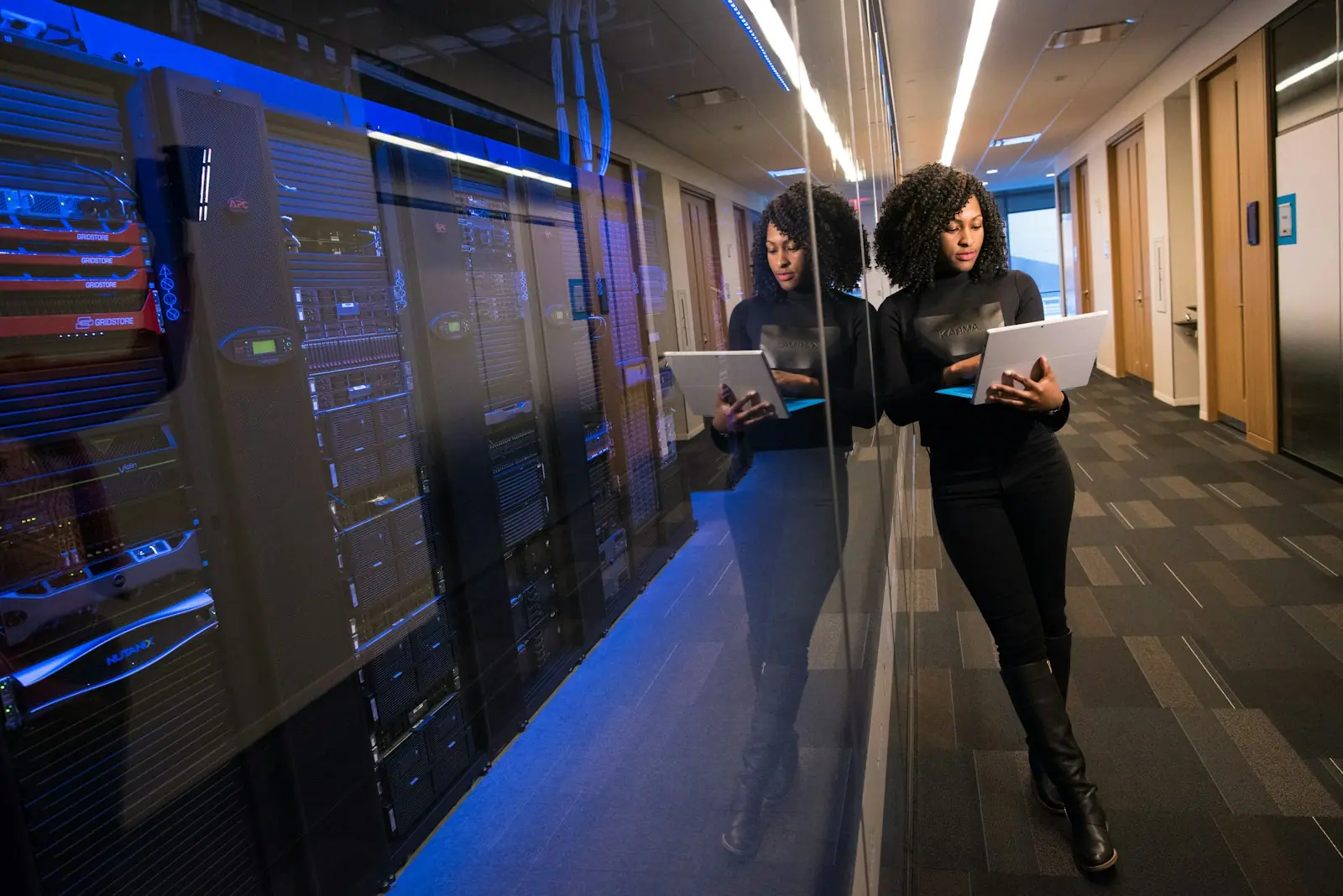 Engineers working with laptops in a data center aisle