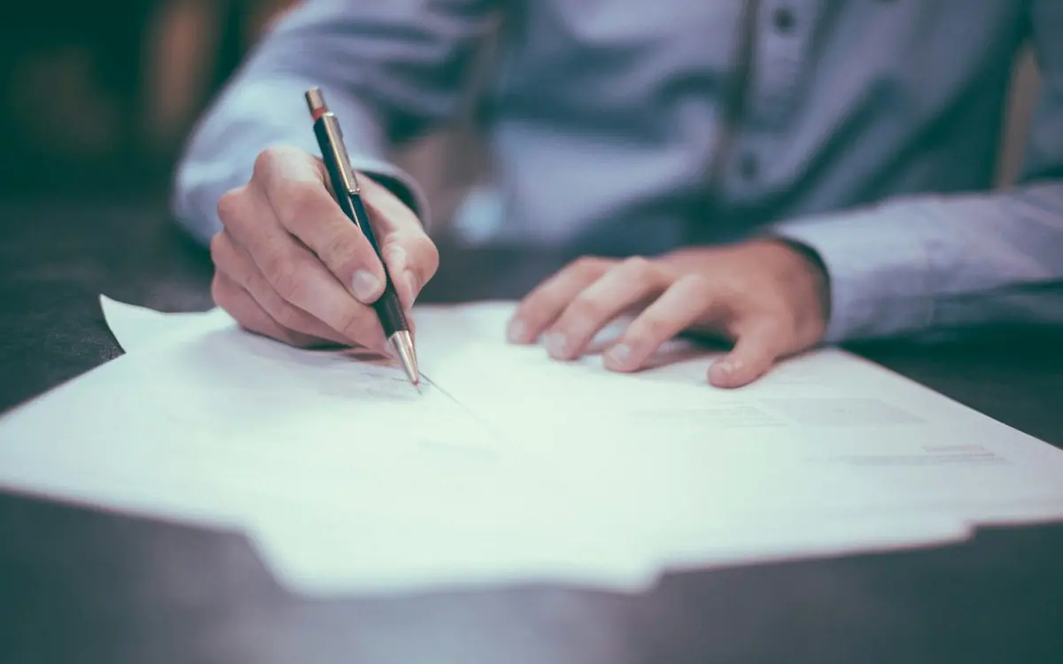 Person reviewing and writing on printed documents