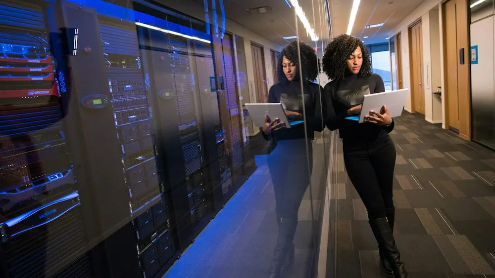 Engineers with laptops in a data centre aisle
