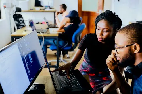 A developer focused on writing code at a laptop