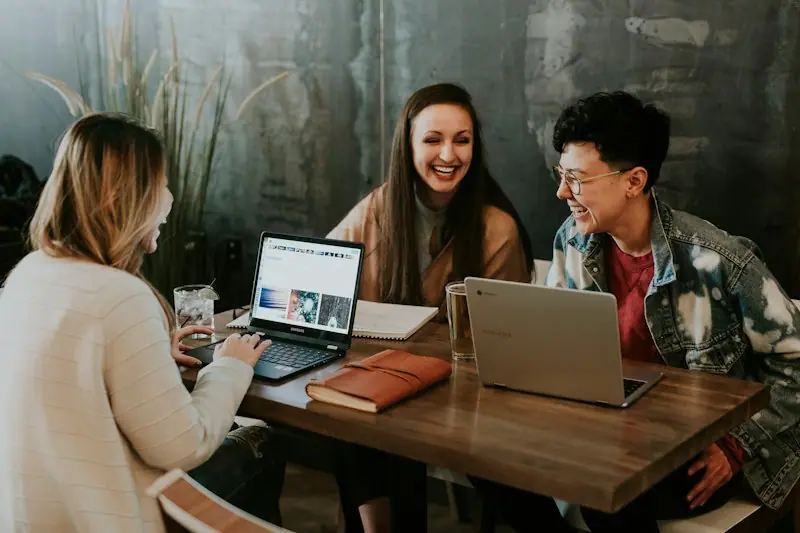 A diverse group of colleagues in a discussion around a laptop