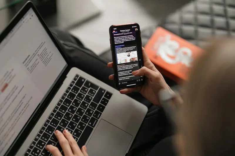 Someone working on a website and checking their phone